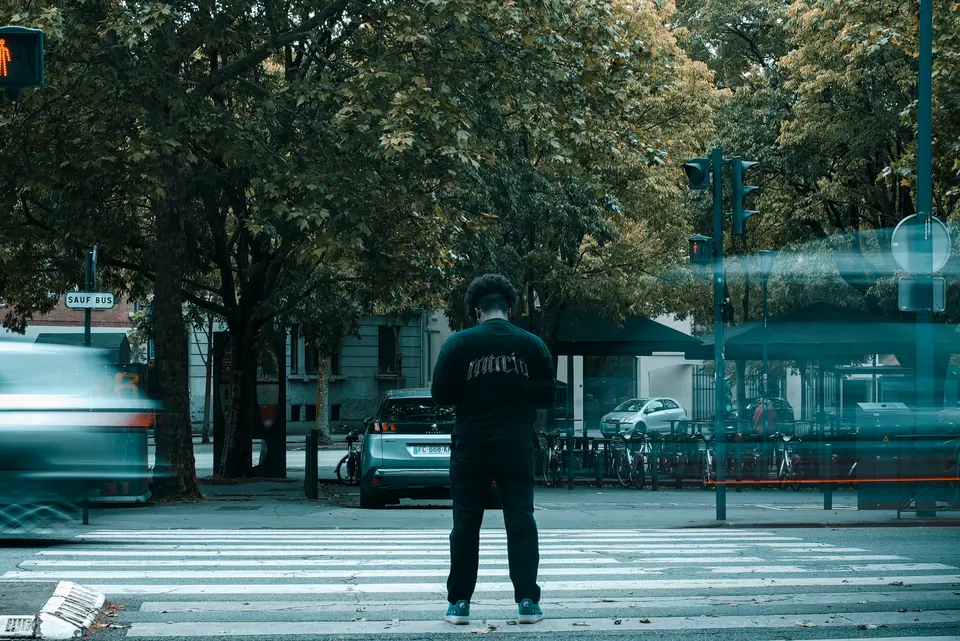 A lone figure crossing a wide street in Toulouse, motion blurred